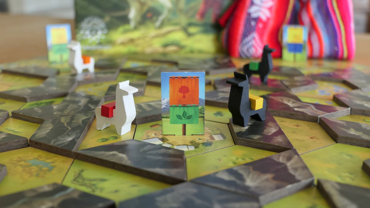 The game board with two llama play-figures next to a flag